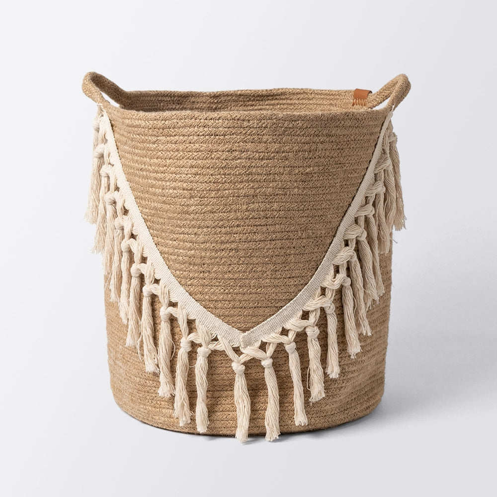 The Bohème Basket is a round, woven باسكت يدوي with two handles and a cream V-shaped fringe on the front, ideal for تخزين وتنظيم. Shown against a plain white background.